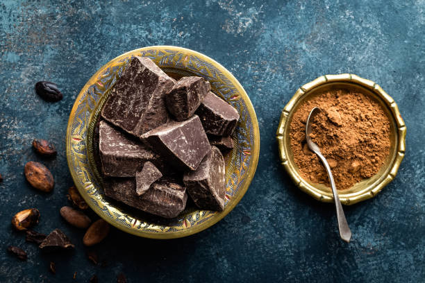 istock Dark chocolate pieces crushed and cocoa beans, culinary background, directly above 654405096