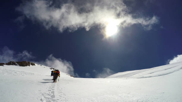 istock Mountaineer climbs snowfield on a sunny day high on a mountain 654405298
