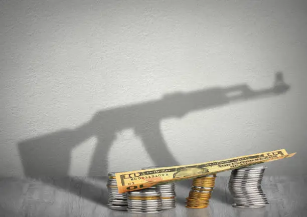 financing terrorism concept, money with weapon shadow