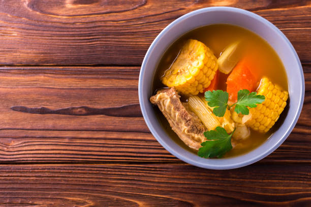 istock Puchero soup with corn and parsley on wooden table 654407754