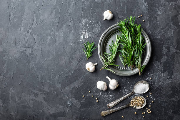 istock Rosemary, garlic, salt and white pepper, culinary background with various spices, directly above, flat lay, copy space 654407942