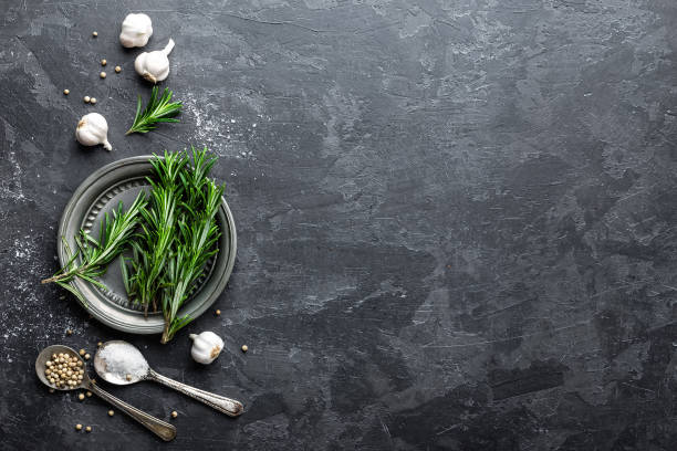 istock Rosemary, garlic, salt and white pepper, culinary background with various spices, directly above, flat lay, copy space 654407996