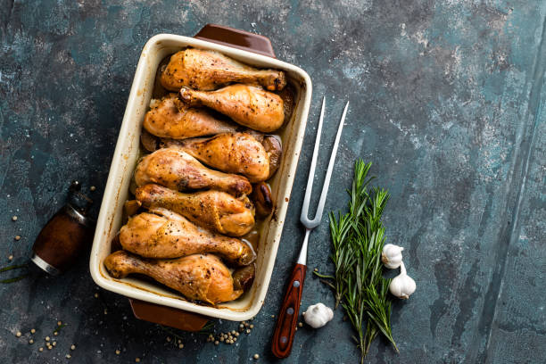 istock Grilled fried roast chicken legs, drumsticks on dark background, meat with ingredients for cooking, top view 654411744