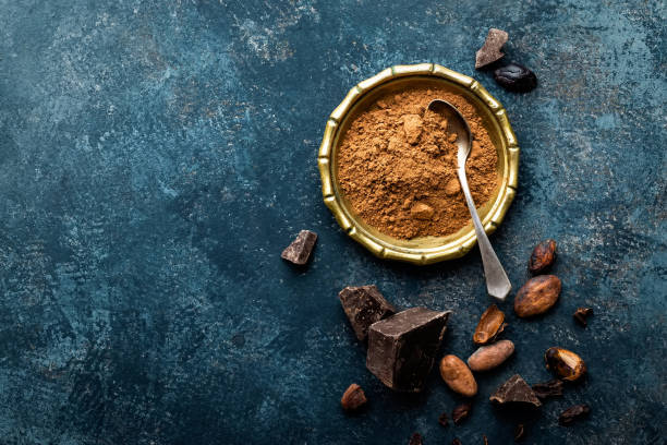 istock Cocoa powder, beans and dark chocolate pieces crushed, culinary background, directly above 654414692