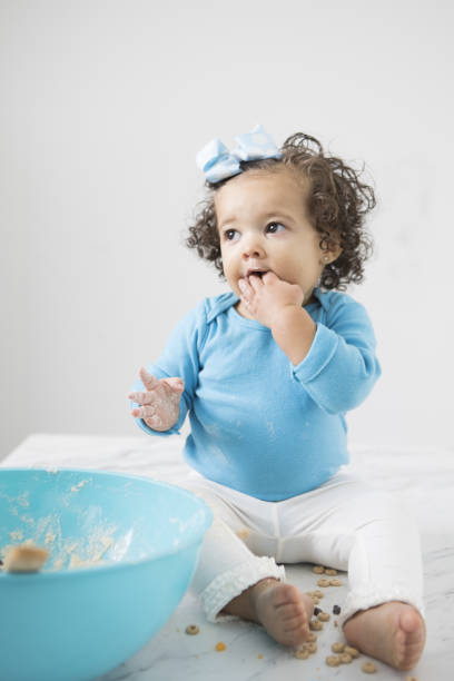 istock Cute bi-racial child playing with a mixing bowl 654424844