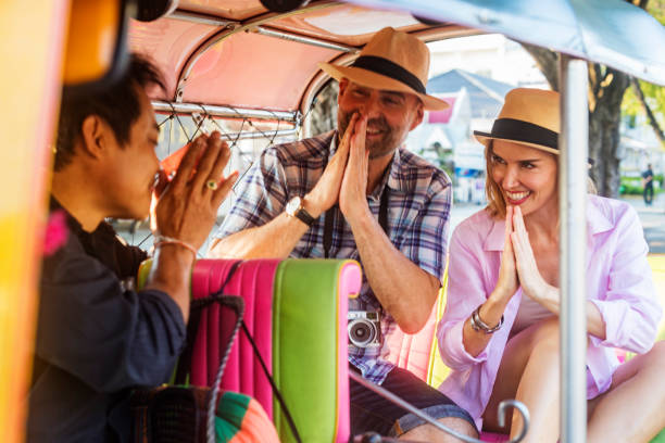 casal maturo de férias pagando respeitosamente driver tuktuk transporte na tailândia - jinrikisha - fotografias e filmes do acervo