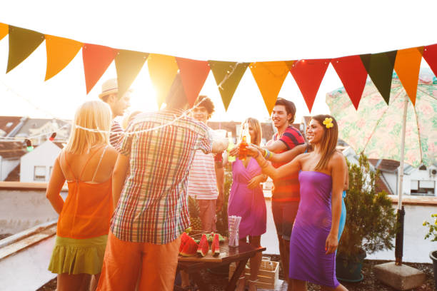istock Friends toasting with drinks at rooftop party 654439948