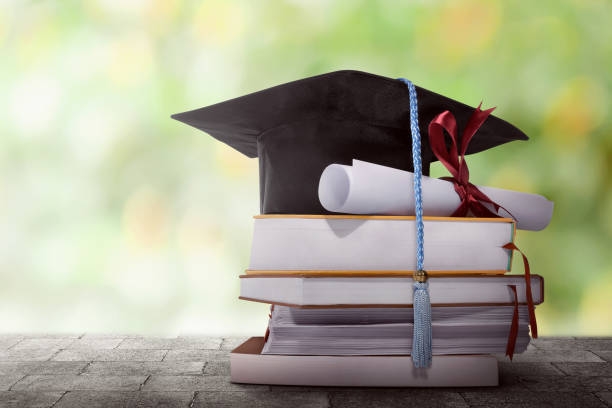 istock Graduation hat with degree paper on a stack of book 654454404