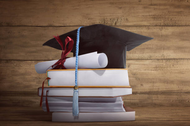 istock Graduation cap with graduation paper on a stack of book 654454466
