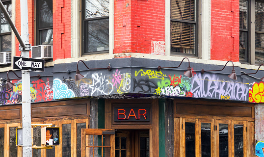 NEW YORK CITY - FEBRUARY 24: A local bar on the corner of Avenue A and St Marks is covered with graffiti in the East Village neighborhood of Manhattan in NYC on January 11th 2017.