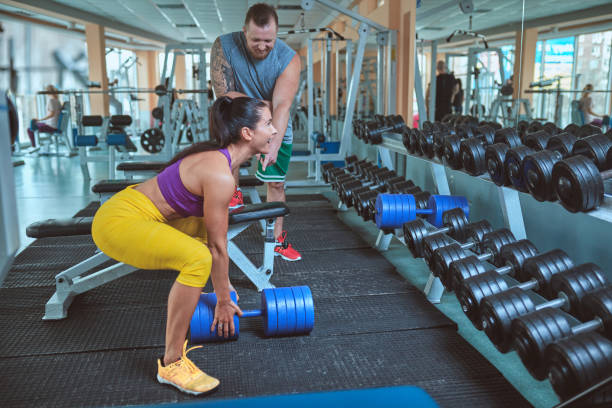 istock woman doing push exercise under supervision of a trainer 654519708