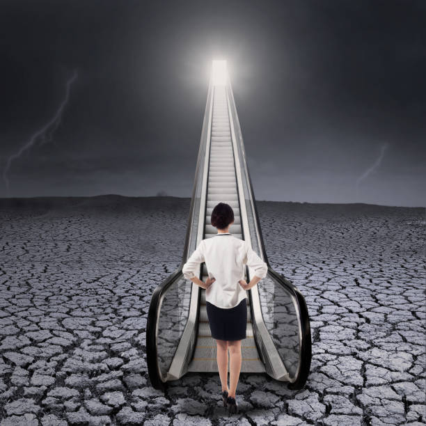 istock Businesswoman on escalator to get her aim 1 654525716