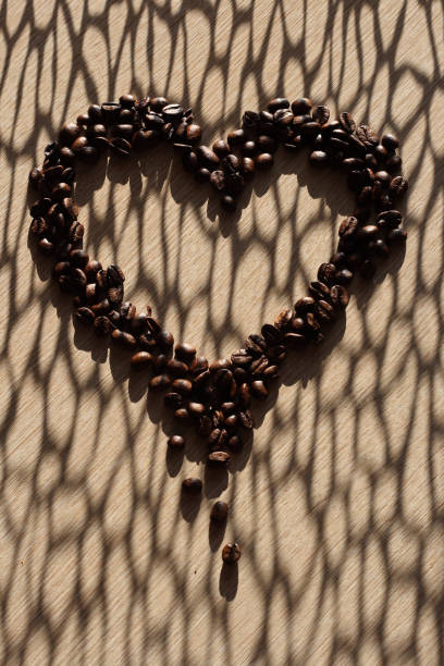 影のあるハートの形をしたコーヒー豆 - barista coffee coffee crop heart shape ストックフォトと画像