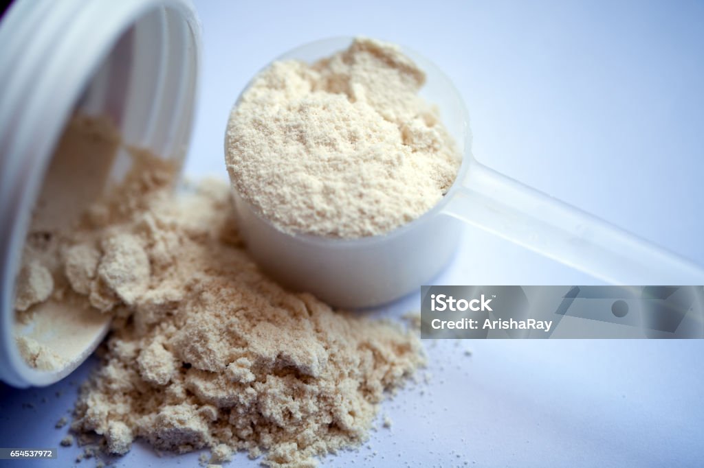 Polvo de proteína de vainilla en primicia sobre fondo blanco - Foto de stock de Suero libre de derechos