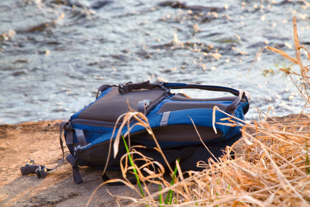 istock The backpack lies on a stone against water flow 654541232