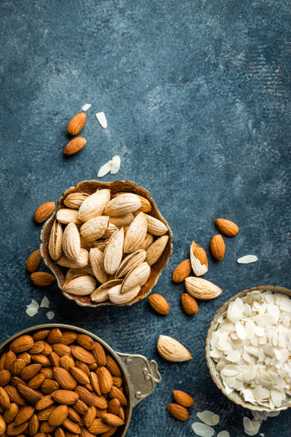 Almond nuts on dark background directly above copy space flat lay