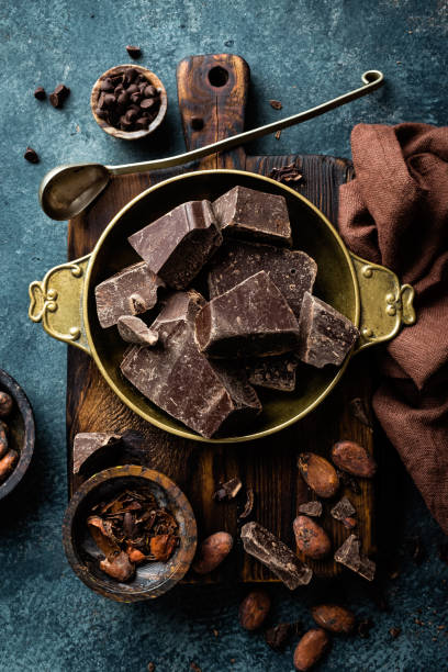 istock Dark chocolate pieces crushed and cocoa beans, culinary background, top view 654544012