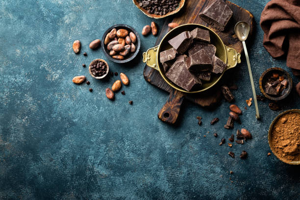 kawałki ciemnej czekolady kruszone i ziarna kakaowca, tło kulinarne, widok z góry - chocolate chocolate shaving ingredient food zdjęcia i obrazy z banku zdjęć