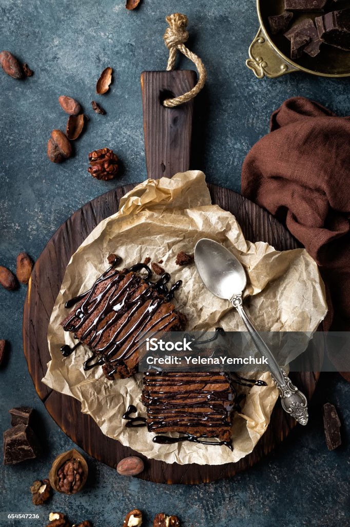 Chocolate brownie cake, dessert with nuts on dark background, directly above, flat lay Baked Stock Photo