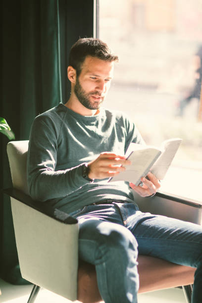 istock Mid Adult man reading book in cafe 654548974