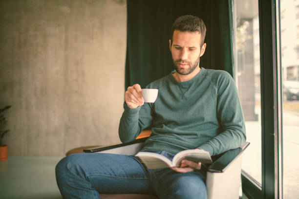 istock Mid Adult man reading book in cafe 654551920