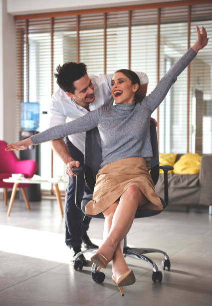 istock Coworkers having fun with swivel chair 654559402