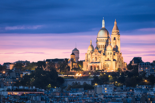 The Basilica of the Sacred Heart (Sacré-Cœur Basilica) during a snow storm in February 2013. Montmartre, Paris, France. Commonly known as Sacré-Cœur Basilica and often simply Sacré-Cœur (French: Basilique du Sacré-Cœur), is a Roman Catholic church and minor basilica, dedicated to the Sacred Heart of Jesus, in Paris, France. A popular landmark, the basilica is located at the summit of the butte Montmartre, the highest point in the city. Sacré-Cœur is a double monument, political and cultural, both a national penance for the defeat of France in the 1871 Franco-Prussian War and the socialist Paris Commune of 1871 crowning its most rebellious neighborhood, and an embodiment of conservative moral order, publicly dedicated to the Sacred Heart of Jesus, which was an increasingly popular vision of a loving and sympathetic Christ.\n