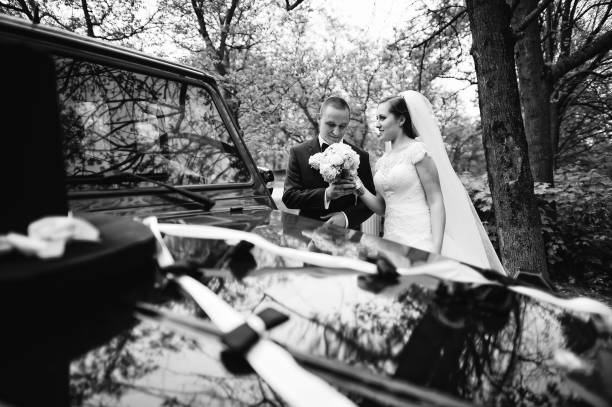 istock Graceful wedding couple background black wedding car 654567444