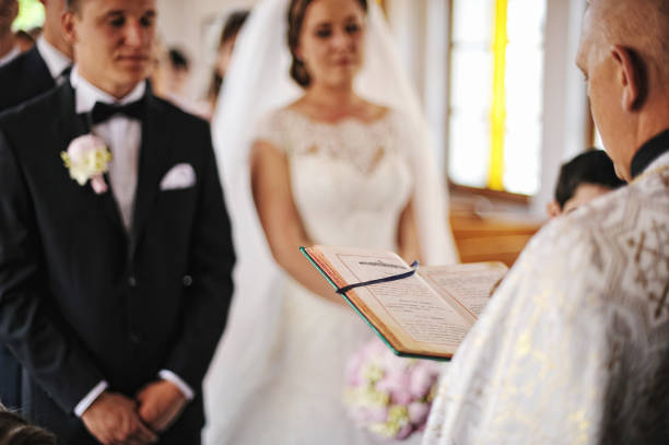 o padre leu um recém-casados holy do fundo do livro da bíblia - church wedding - fotografias e filmes do acervo