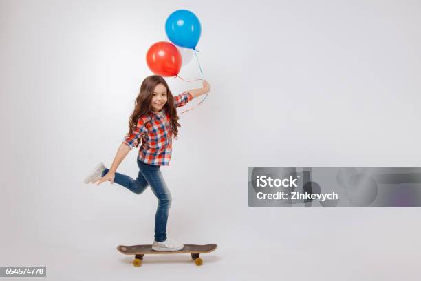 Outgoing Girl Using Skateboard In The Studio Stock Photo - Download Image Now - Balloon, Child, Childhood