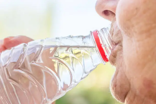 Close up Senior Woman drinking fresh water from the bottle