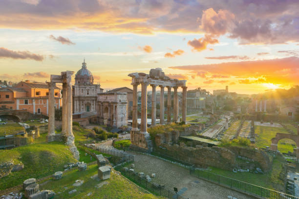 The Roman Forum at sunrise, Rome, Italy Left to right: Arch of Septimius Severus, the ruins of Temple of Saturn, the remains of the colonnade of Basilica Julia, the ruins of Temple of Castor and Pollux (the ruin with three columns). Arch of Titus is visible in the distance. unesco world heritage site stock pictures, royalty-free photos & images