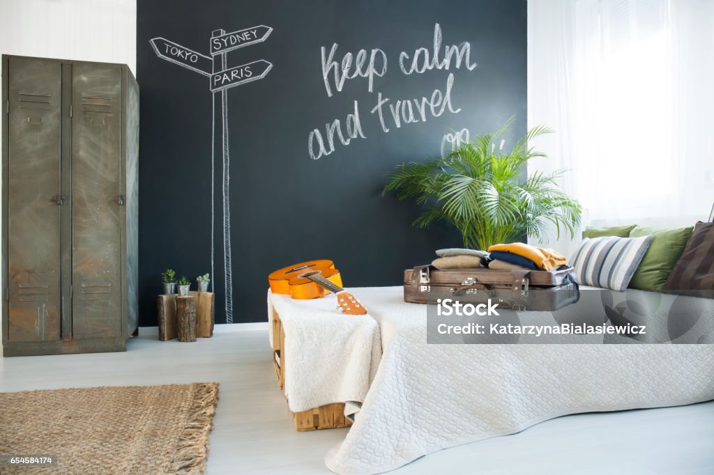 Bed in cozy bedroom King-size bed in cozy bedroom with chalkboard wall Travel Stock Photo