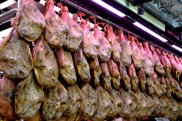 Depot with rows of jamon on the racks at market in Valencia, Spain