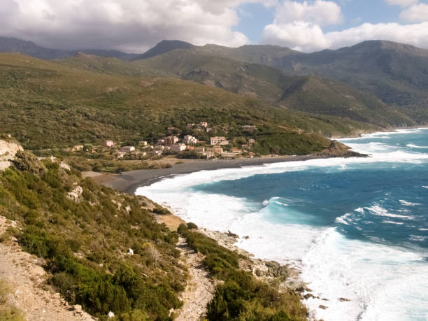Beach with strong Mistral wind Corsica, France: Coast of Cap Corse and Nonza Beach in rough seas and strong Mistral wind mistral wind stock pictures, royalty-free photos & images