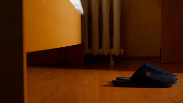 istock Slippers on a floor near a bed 654597606