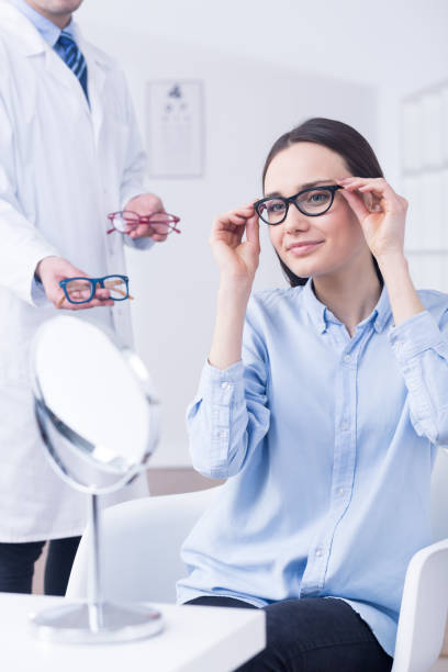 istock Optician and woman choosing eyeglasses 654603568