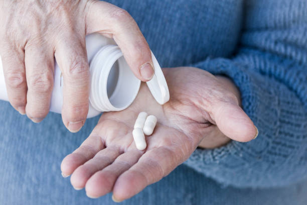 istock Drug pills on wold oman's hand 654604876
