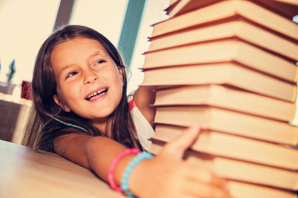 istock Little girl with a stack of books 654605238
