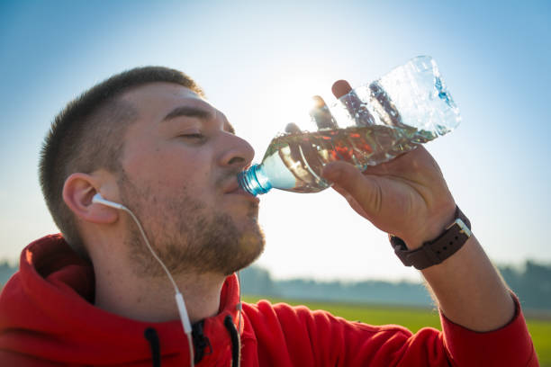 istock Sportsman drinking water after running 654609166