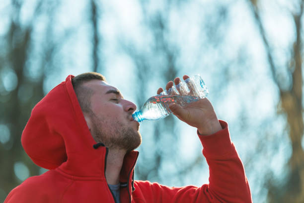 istock Sportsman drinking water after running 654609192