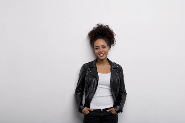 istock Stylish woman posing against white wall with hands in pocket 654621054