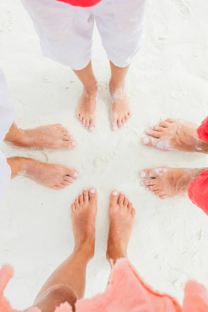 Top view image of feet Top view image of feet of family standing on the white sand beach. crop top view stock pictures, royalty-free photos & images
