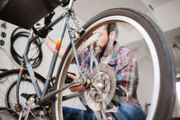 istock Repairman repairing bicycle in workshop 654623336
