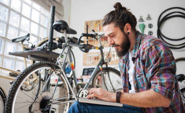 istock Repairman repairing bicycle in workshop 654623520