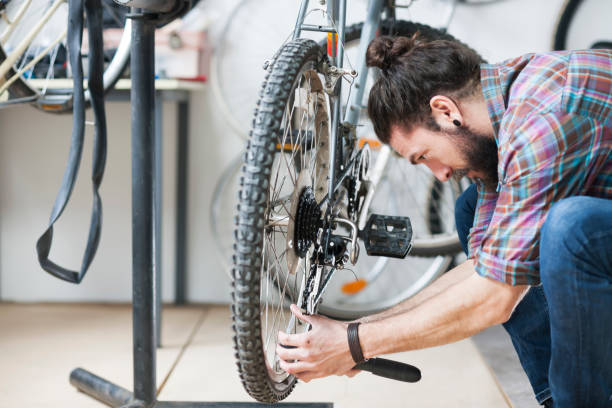 istock Repairman repairing bicycle in workshop 654623546