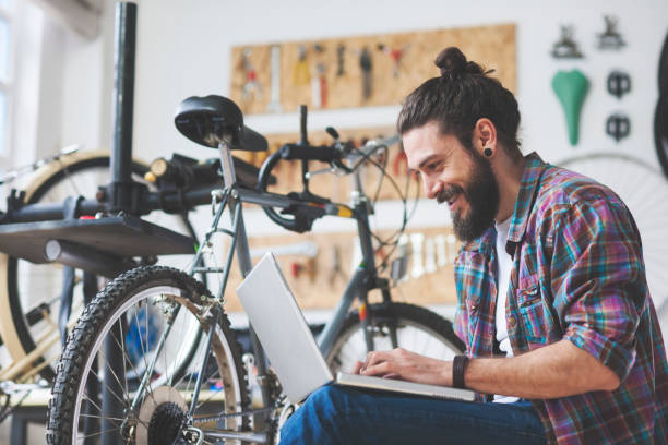 istock Repairman repairing bicycle in workshop 654623594
