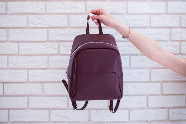 istock Women’s backpack of marsala color in hand 654626462