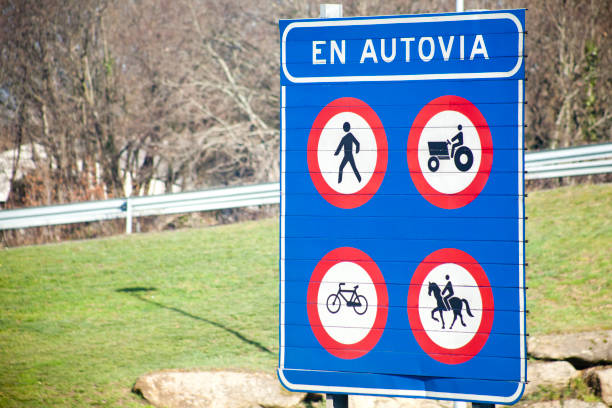 Highway entrance, text in spanish language, road warning sign. Entrance of people, horseback riding, bicycle, tractors forbidden. Galicia, Spain. Copy space on the left.