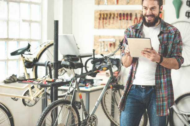 istock Repairman repairing bicycle in workshop 654639716
